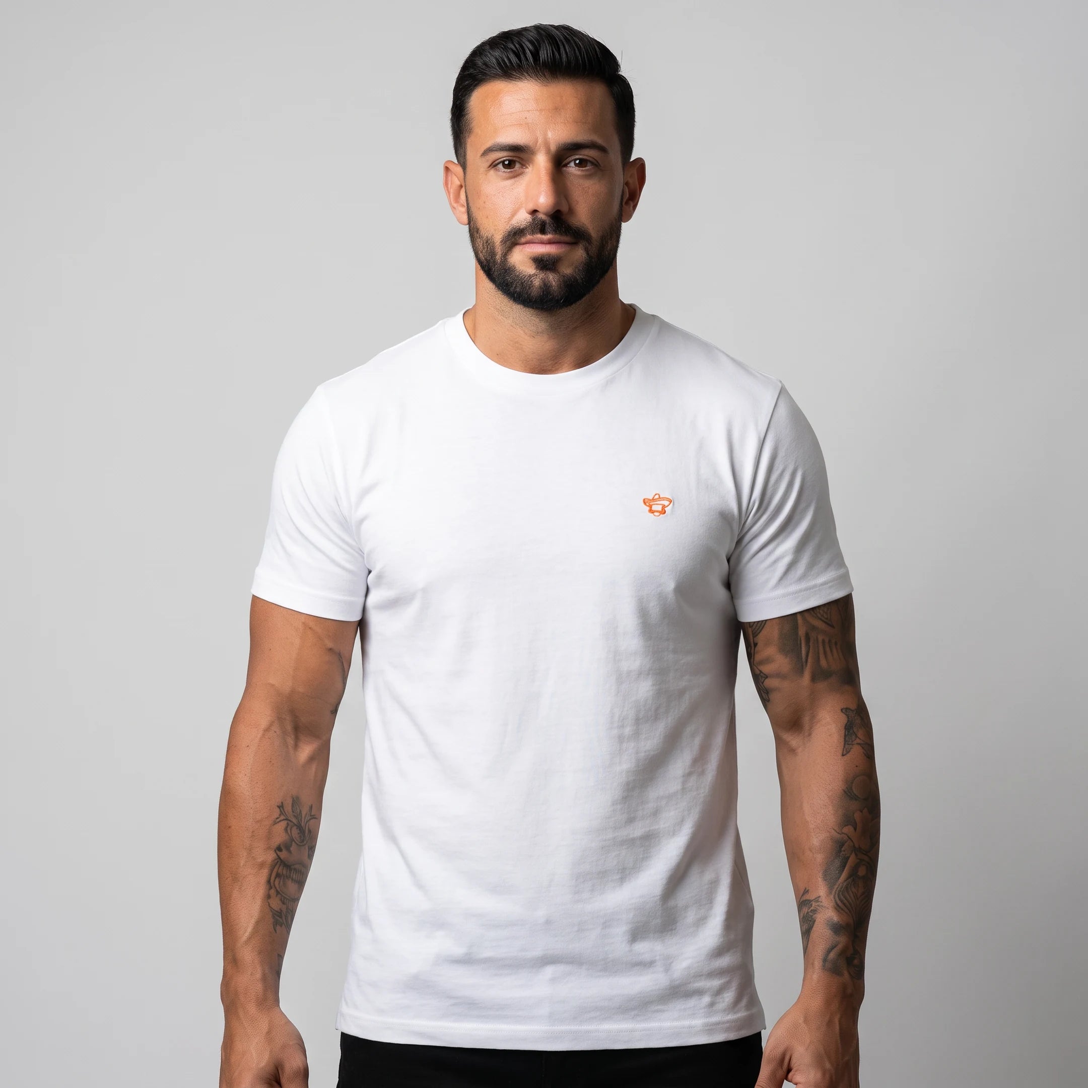 Camiseta Class blanca de Knockout Couture en modelo, busto de frente con logo bordado en naranja flúor — camiseta de vestir de algodón orgánico